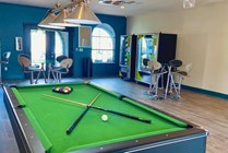 Billiards table and vending machine in clubhouse.